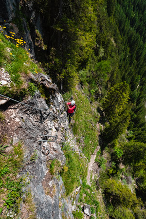 Climber climbing up a stone wall in a natural forestの写真素材