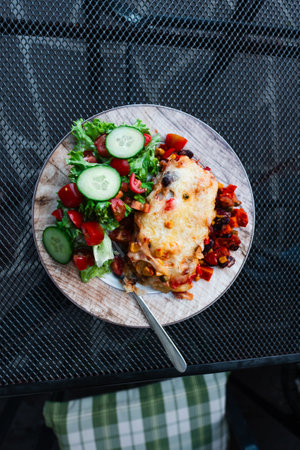 Lasagna on a Big Plate with a Green Fresh Saladの写真素材