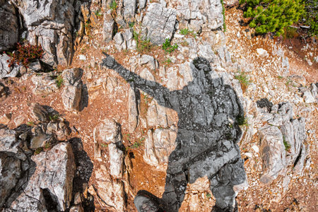 POV View of a Hiker's Shadow Pointing into the Leading Direction on a Stony Hiking trailの写真素材