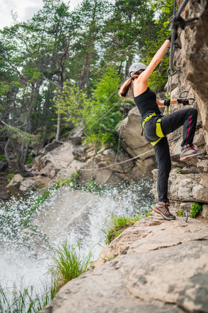 Woman Climber Starting to Cross Waterfall Rope on via Ferrata