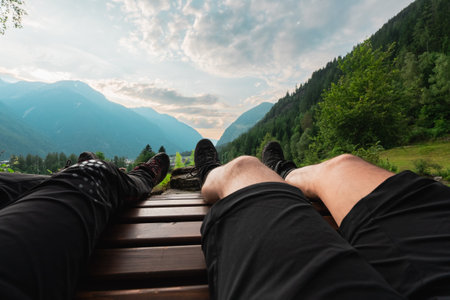 Resting Hiker on a Hike Bench in Nature in a Mountain Landscape Looking at the Cloudsの写真素材