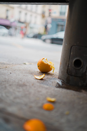 Peeled Orange Lying on the Concrete Floor of the Cityの写真素材
