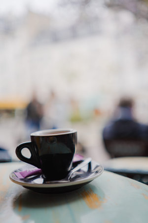 Espresso Coffee in a Small Black Cup and Plate Standing on a Wooden Table