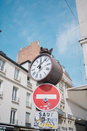 Classic Clock Standing on Top of a Sign Post in the City During Summer