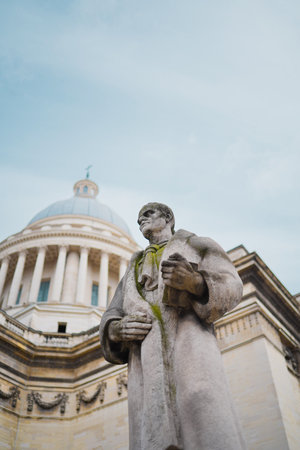 Weathered Stone Statue of a Counselor Man Representing Law and Order Holding a Book in a Robe Near the Parliamentの写真素材