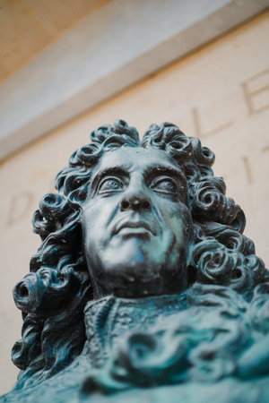 Face of a Green Statue Representing a Man with Long Curly Hair in Classical Style Looking to the Sideの写真素材