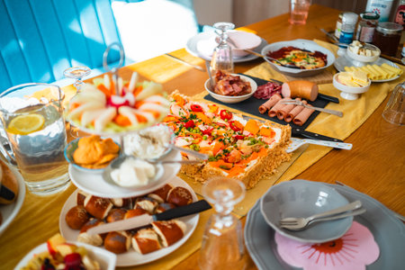 Vibrant brunch setup featuring a variety of colorful dishes, fresh salads, cheeses, meats, and beverages. The lively arrangement creates a warm and inviting atmosphere for gatherings and celebrationsの写真素材