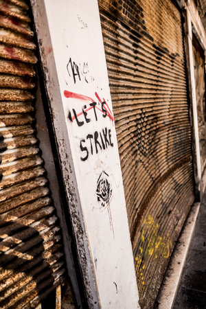 An urban scene from Venice showing graffiti art with the powerful message 'Let's Strike,' set against a weathered metal wall, embodying street art culture and protest expression.の写真素材