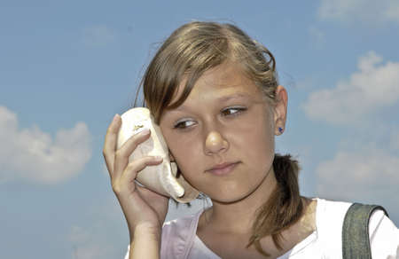 The girl press to his ear and listening the sounds of shellの写真素材