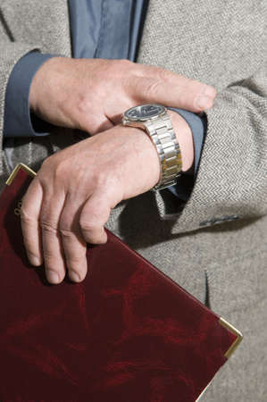  	 The businessman looks at the watch checks the amount of time left before the meetingの写真素材