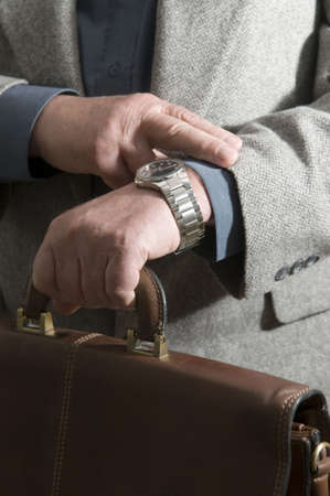  	 The businessman looks at the watch checks the amount of time left before the meetingの写真素材