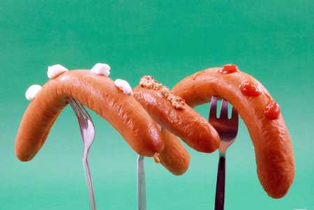 	Three sausages with different spices put on forksの写真素材