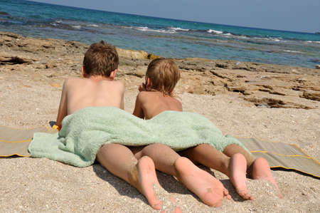 The boys lie on the beach and dream of distant travelsの写真素材