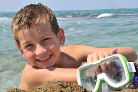 A boy with a mask  for diving, poses a photographerの写真素材