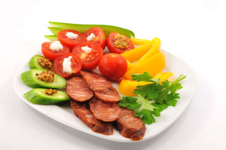 Spicy Hungarian sausage with chopped ovoshami lies on a plateの写真素材