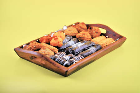 Easter baking on a wooden tray on a yellow backgroundの写真素材
