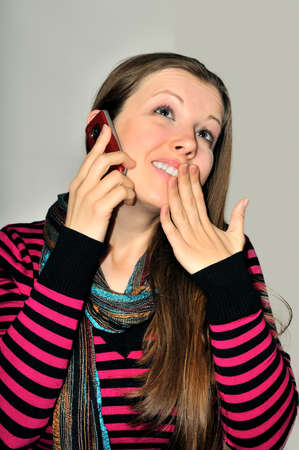 A young girl emotionally expressive talking on a mobile phoneの写真素材