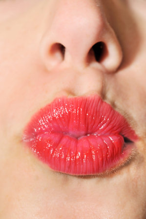 Model folded his lips and put them forward showing red lipstick