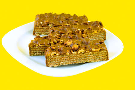 Sliced ââwafers coated peanuts and chocolate filled, lie on the white plateの写真素材