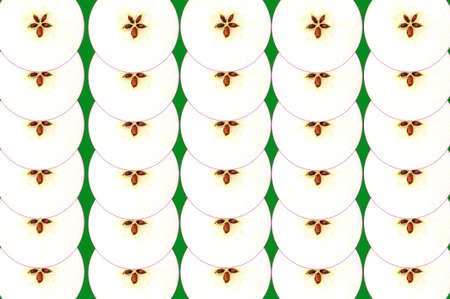 Collage of cut apples packed in rows against a green backgroundの写真素材