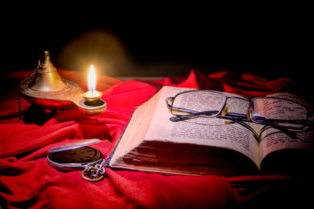 Torah is on the table, covered with a cloth, lit the lamp, man came out not long time left the glasses on the bookの写真素材