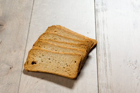 Crackers   lie on a wooden table, photographed in contrasts