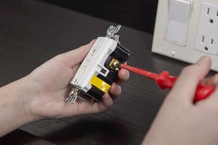 Checking the electrical outlet before installing it in a junction box on the wallの写真素材
