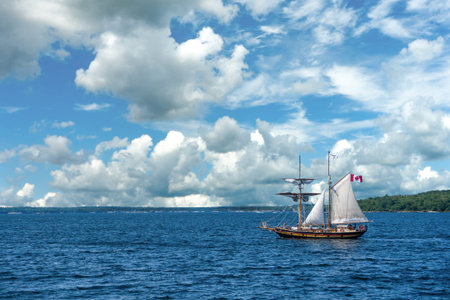 Cruise on the large lakes of Canada and America under a blue sky with white clouds on a two-masted...
