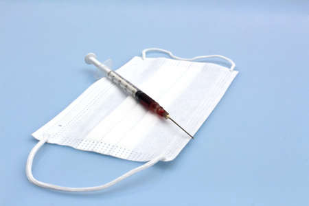 syringe with blood on blue backgroundの写真素材