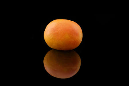 a grapefruit on black background with reflectionの写真素材