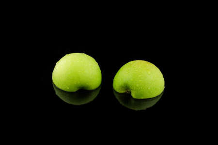 a green sliced apple on blackの写真素材