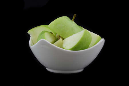 green apple split into a porcelain bowlの写真素材