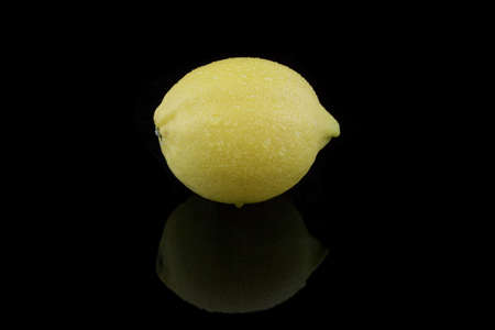 a whole lemon with water on black backgroundの写真素材