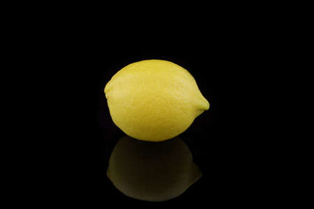 one yellow lemon on black backgroundの写真素材
