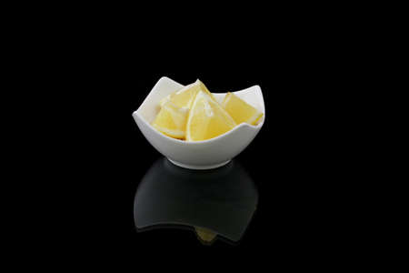 lemons morsels in a dish on blackの写真素材