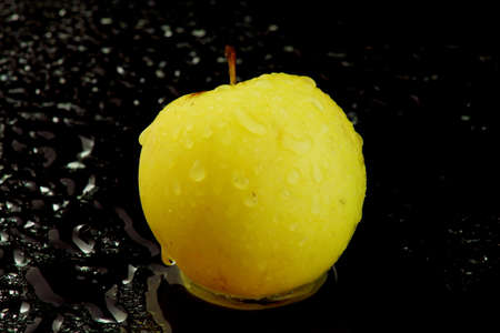 a yellow whole apple on waterの写真素材