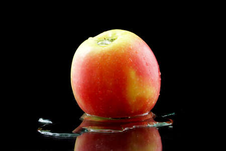 a yellow red apple on black backgroundの写真素材