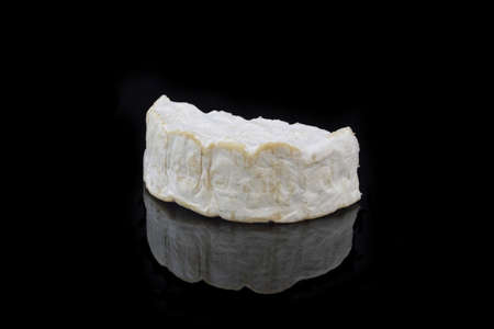 a piece of camembert cheese on black backgroundの写真素材