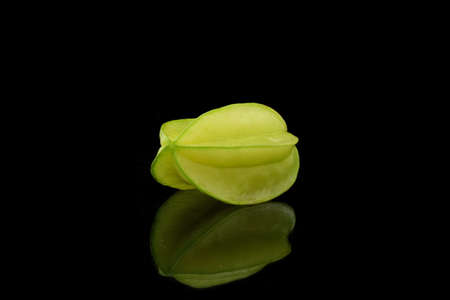 One is reflecting starfruit on black backgroundの写真素材