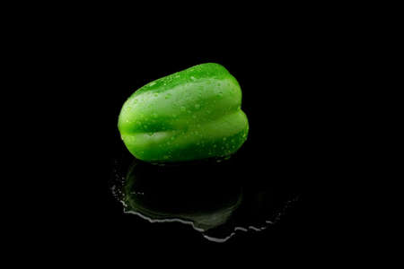 a green bell pepper with water on a black backgroundの写真素材