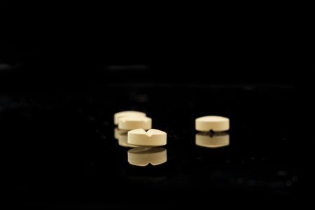 four yellow tablets on black background