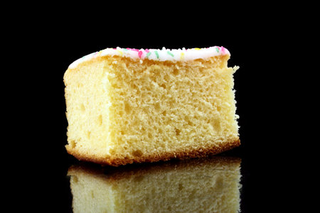 a piece of lemon cake on black background