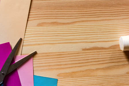 Construction paper with scissors on woodの写真素材