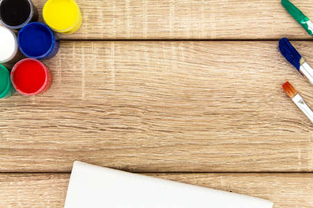 Paint cans with brush and canvas on wooden backgroundの写真素材