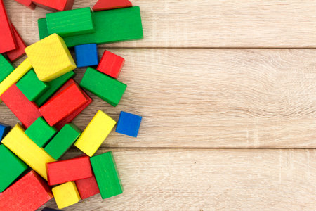 Different building blocks of wood on a wood backgroundの写真素材