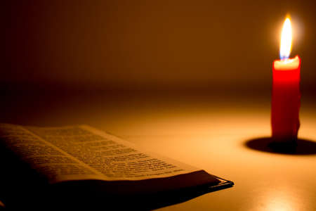 The bible with candle and candle lightの写真素材