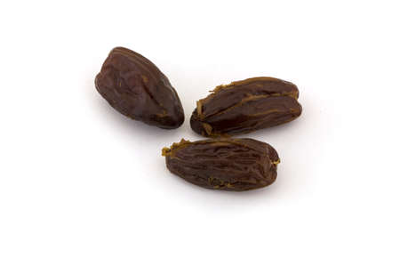 three dried dates on a white backgroundの写真素材