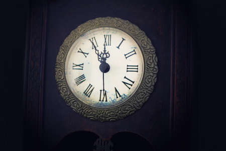 twelve o'clock on an old clockの写真素材