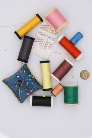 Sewing articles, multicolored bobbins, needles, thimbleの写真素材