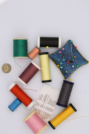 Sewing articles, multicolored bobbins, needles, thimbleの写真素材